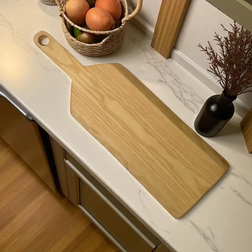 Tagliere artigianale forma irregolare con manico in legno massello di frassino, lungo e stretto con foro sul manico per appenderlo.