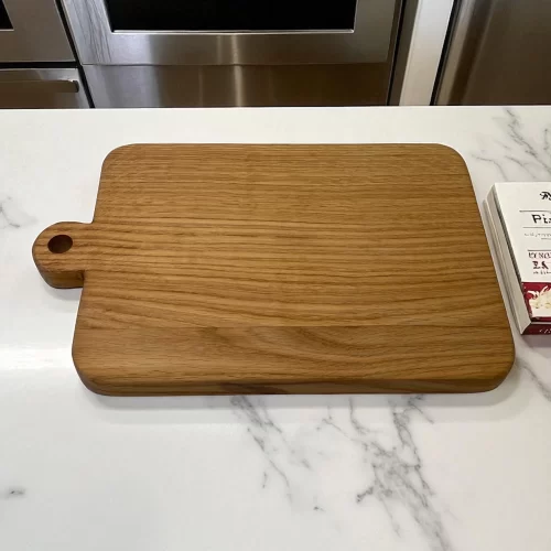 Rectangular cutting board in solid wood, handcrafted with a hanging hole, ideal for serving and cutting food in the kitchen.