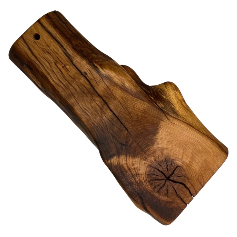 Irregular handcrafted solid wood cutting board with hanging hole, ideal for serving and cutting food in the kitchen.