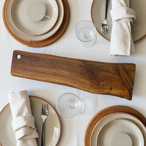 Irregular, narrow and long solid wood cutting board with a hanging hole, ideal for serving and cutting food in the kitchen.