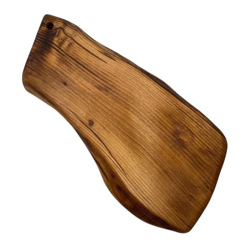 Irregular solid wood cutting board with hanging hole, ideal for serving and cutting food in the kitchen.