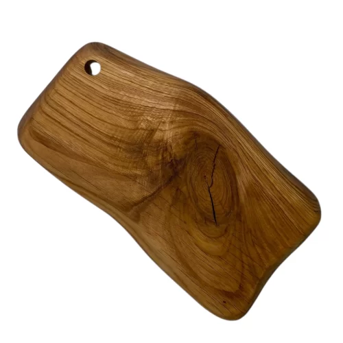 Irregular solid wood cutting board with hanging hole, ideal for serving and cutting food in the kitchen.