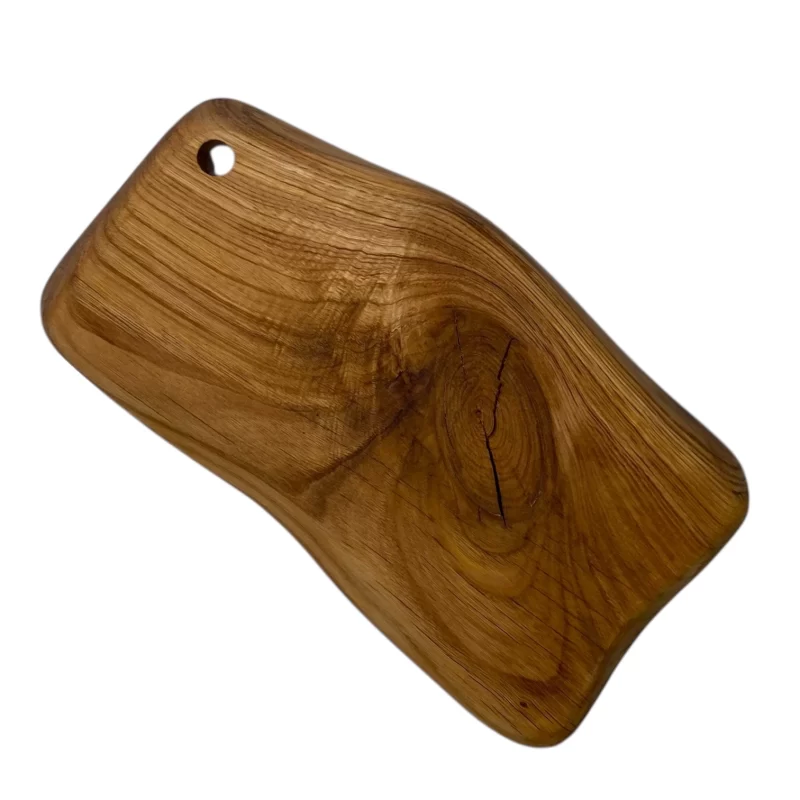 Irregular solid wood cutting board with hanging hole, ideal for serving and cutting food in the kitchen.
