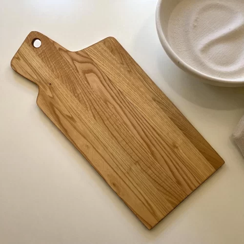 Handcrafted rectangular cutting board with hand-sanded solid wood handle and hanging hole, ideal for serving appetizers and cutting food.