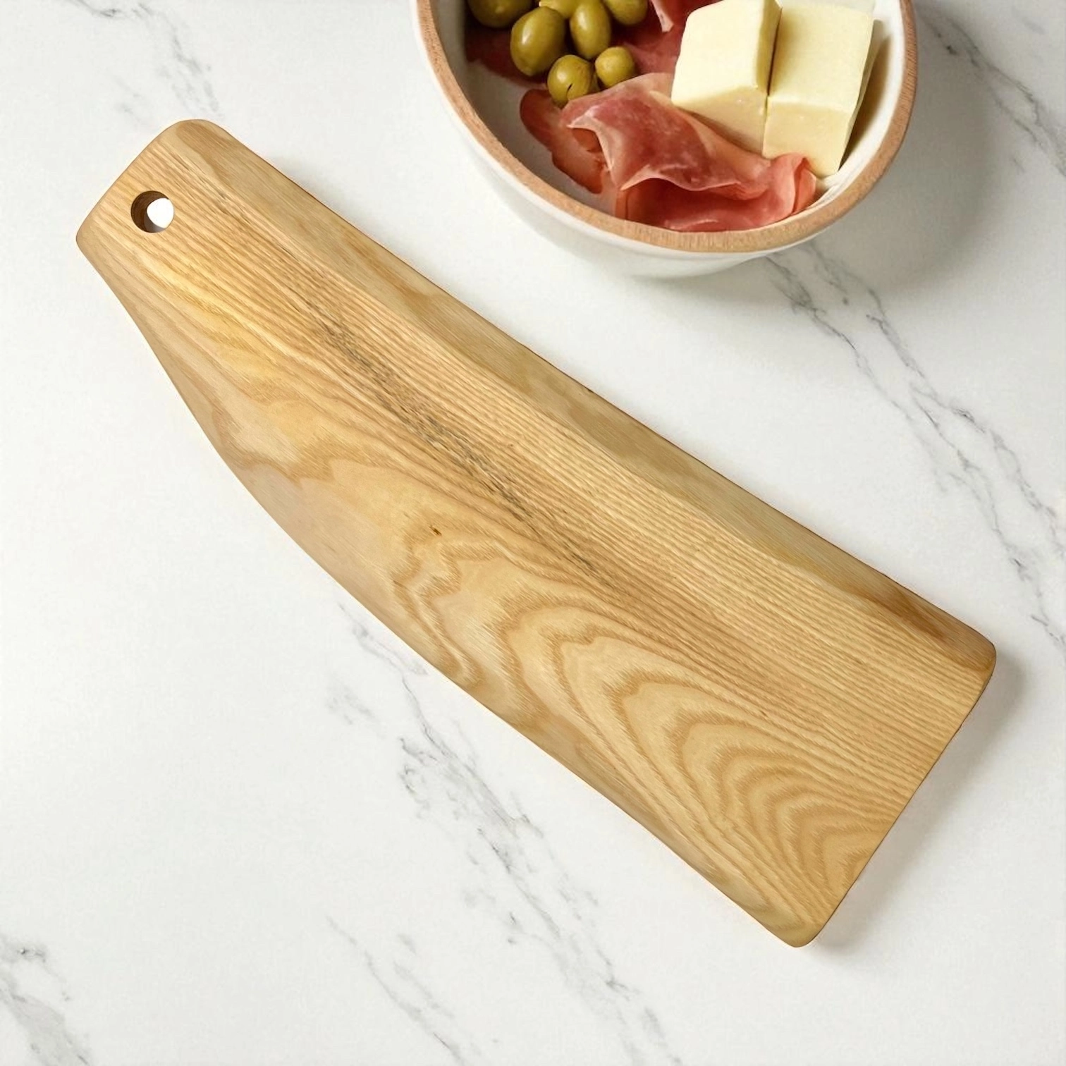 Tagliere artigianale in legno massello di frassino con forma irregolare naturale e venature chiare