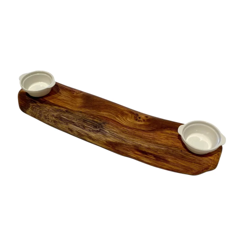 Tagliere artigianale in legno rettangolare stretto e lungo con bordo irregolare e due ciotole in ceramica bianca per marmellate, salse o caffè.