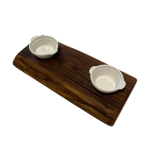 Tagliere artigianale in legno rettangolare stretto e lungo con bordo irregolare e due ciotole in ceramica bianca per marmellate, salse o caffè.