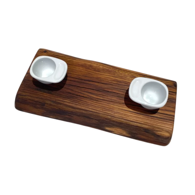 Tagliere artigianale in legno rettangolare stretto e lungo con bordo irregolare e due ciotole in ceramica bianca per marmellate, salse o caffè.